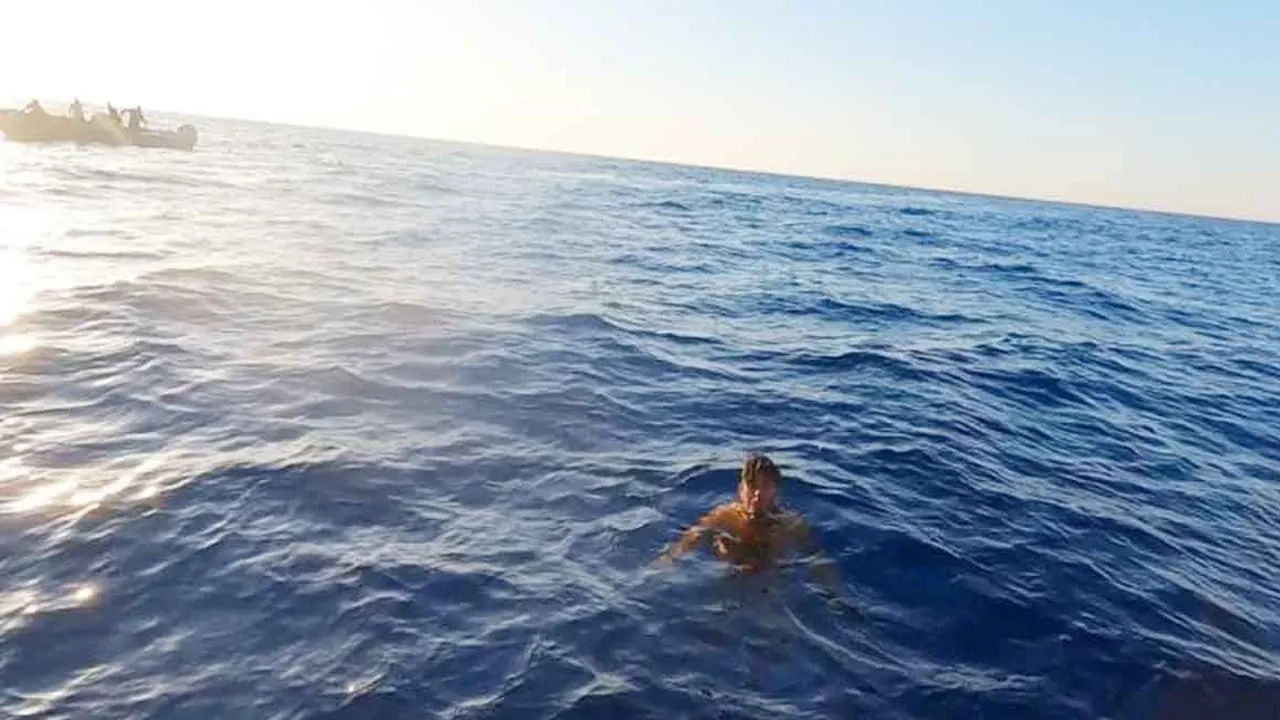 লিবিয়ার উত্তর-পশ্চিমাঞ্চলীয় আল-খুমস উপকূলে ডুবে যাওয়া নৌকা থেকে এক যাত্রী তীরে আসার চেষ্টা করছেন