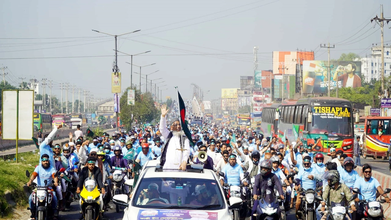 ছাদখোলা গাড়িতে দাঁড়িয়ে দুই পাশের পথচারীদের দিকে হাত নেড়ে শুভেচ্ছা জানান প্রার্থী কাজী দ্বীন মোহাম্মদ