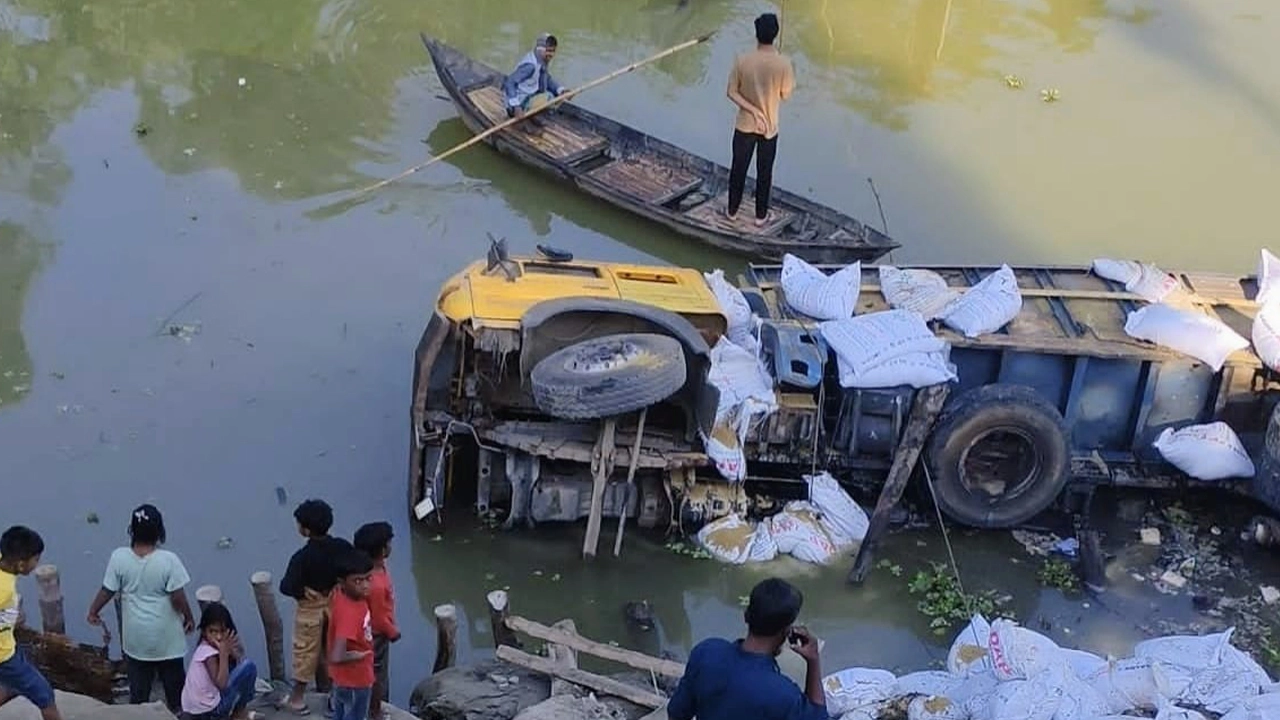 ঘিওরে সার বোঝাই একটি ট্রাক নিয়ন্ত্রণ হারিয়ে উল্টে গিয়ে সোজা নদীতে পড়ে যায়