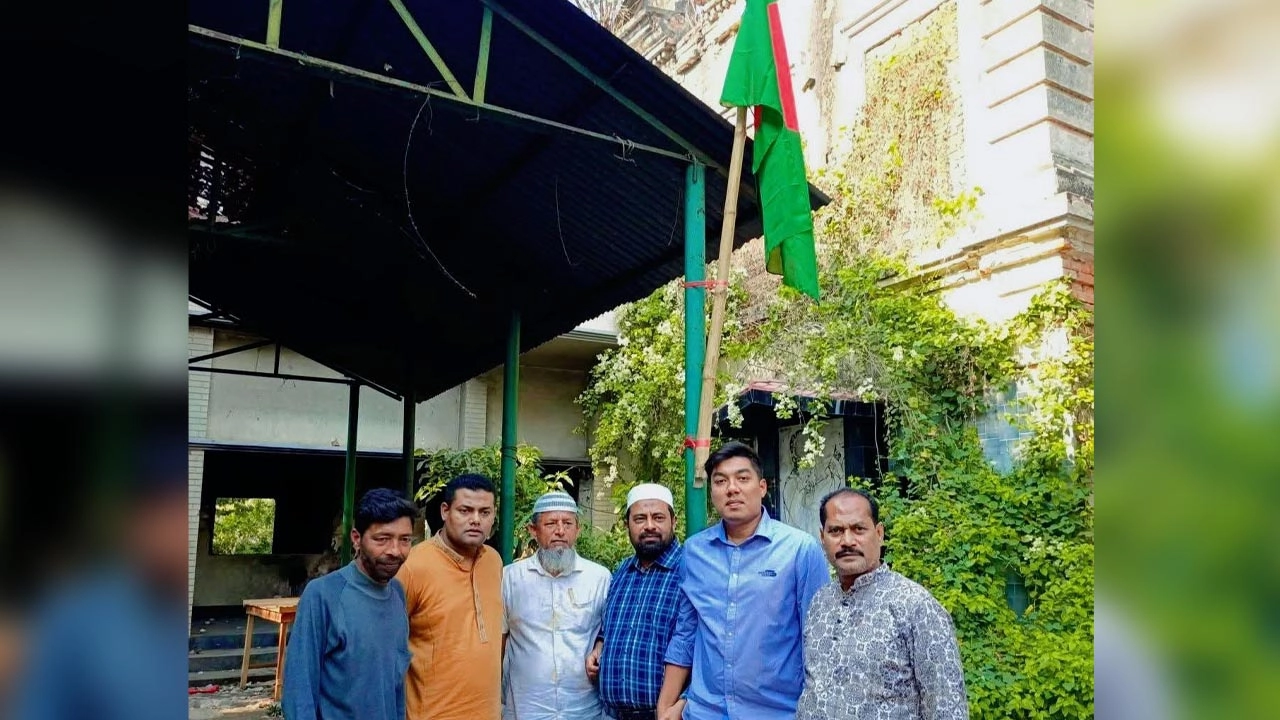 নেতাকর্মীরা একটি লাঠিতে করে জাতীয় পতাকা উত্তলন করেছেন