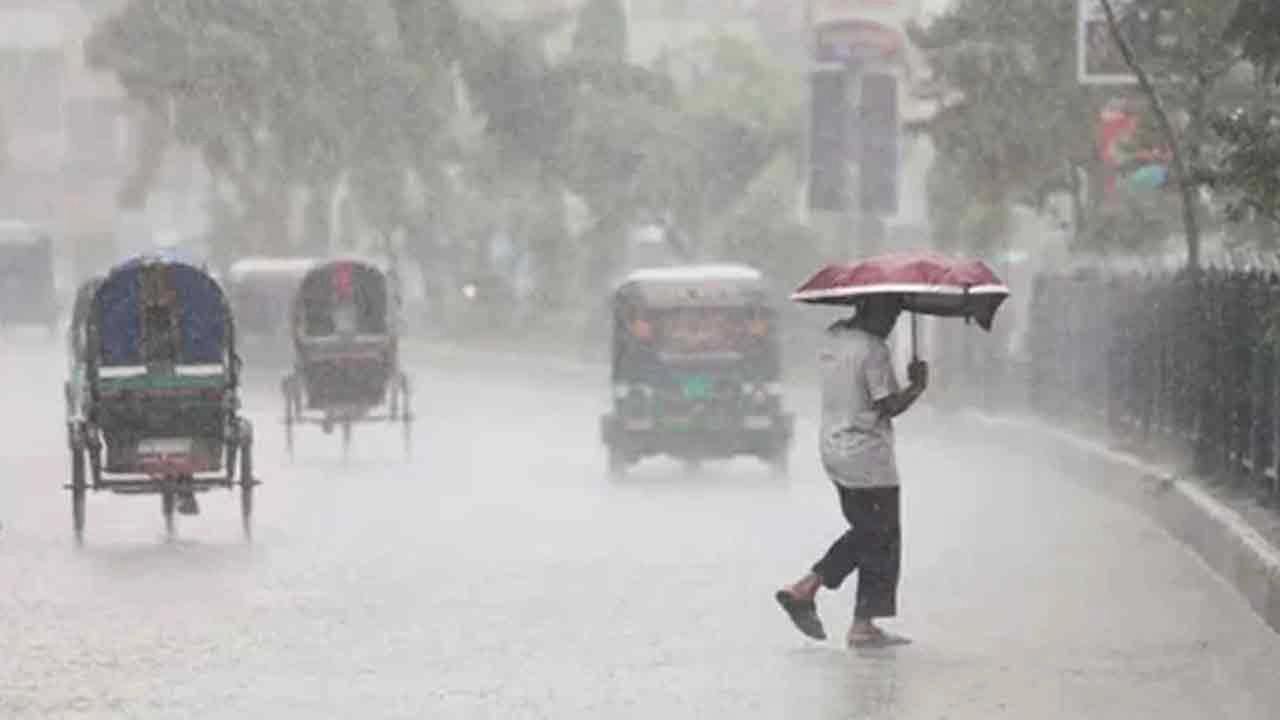 বৃষ্টির মধ্যে রাস্তা পার হচ্ছেন পথচারী। পুরোনো ছবি