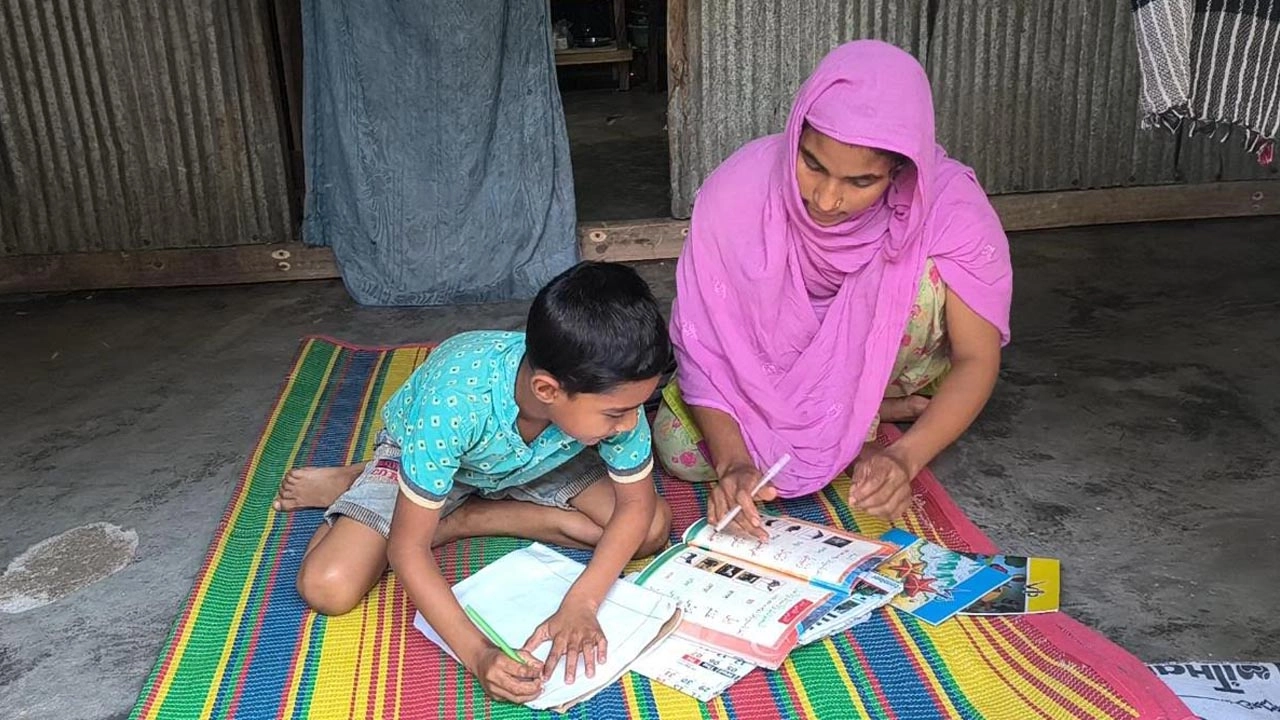মায়ের সঙ্গে পড়ছেন ৮ বছর বছরের শিশু মো. আবদুর রহমান