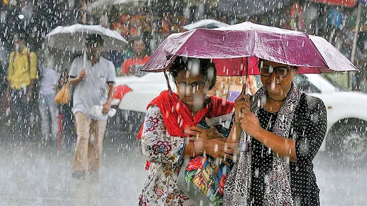 বৃষ্টির সময় ছাতা মাথায় হাঁটেন পথচারীরা